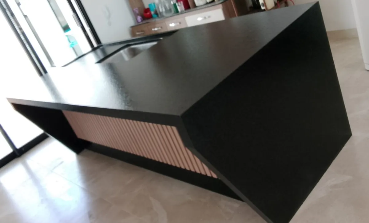 Área gourmet com ilha em granito preto e detalhe ripado em madeira