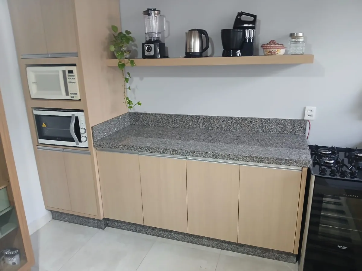 Cozinha com bancada em granito cinza e eletrodomésticos embutidos